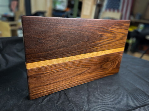 Walnut cutting board with maple accent stripe